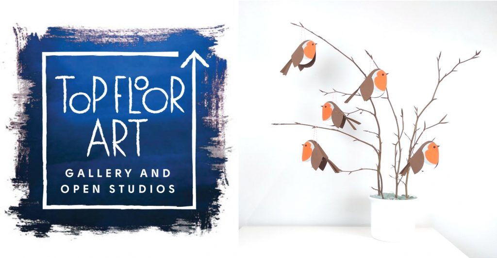 Logo for Top Floor At Gallery next to a photograph of paper robins hanging on an ornamental twig arrangement