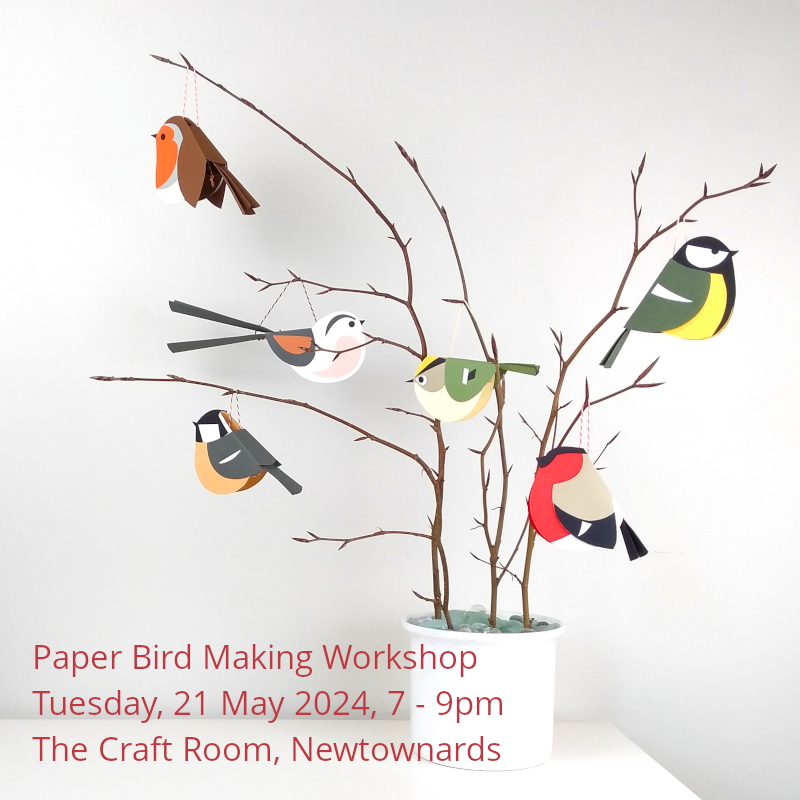 A photograph of paper birds hanging from beech twigs inserted into a white ceramic pot. Red text reads"Paper Bird Making Workshop, Tuesday 21 May 2024, 7-9pm, the Craft Room Newtownards