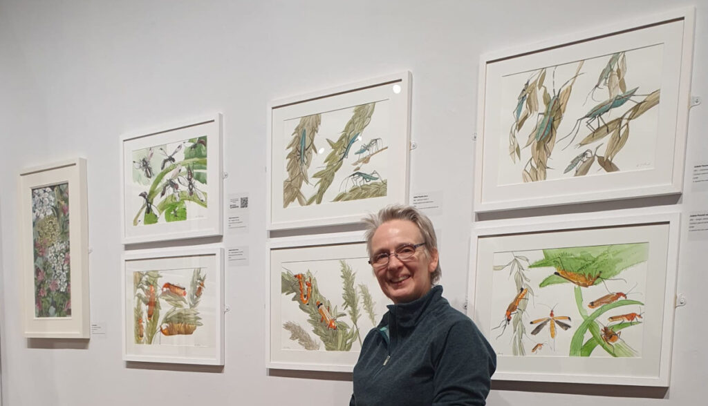 Adele Pound photographed next to her pieces exhibited at the Natural Eye Exhibition